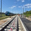 Ein Abstellgleis am Waldrand, am Nachbargleis ein Doppelstockzug
