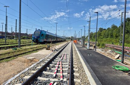 Ein Abstellgleis am Waldrand, am Nachbargleis ein Doppelstockzug