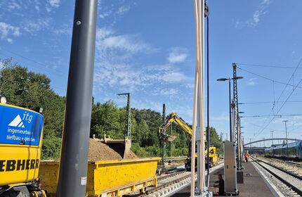 T-System-Säulen, im Hintergrund Bauwaggons auf dem Abstellgleis