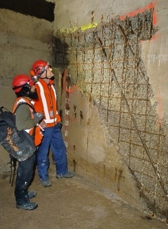 Zwei Personen führen umfangreiche Untersuchungen durch für die Betonsanierung der Brückenpfeiler.
