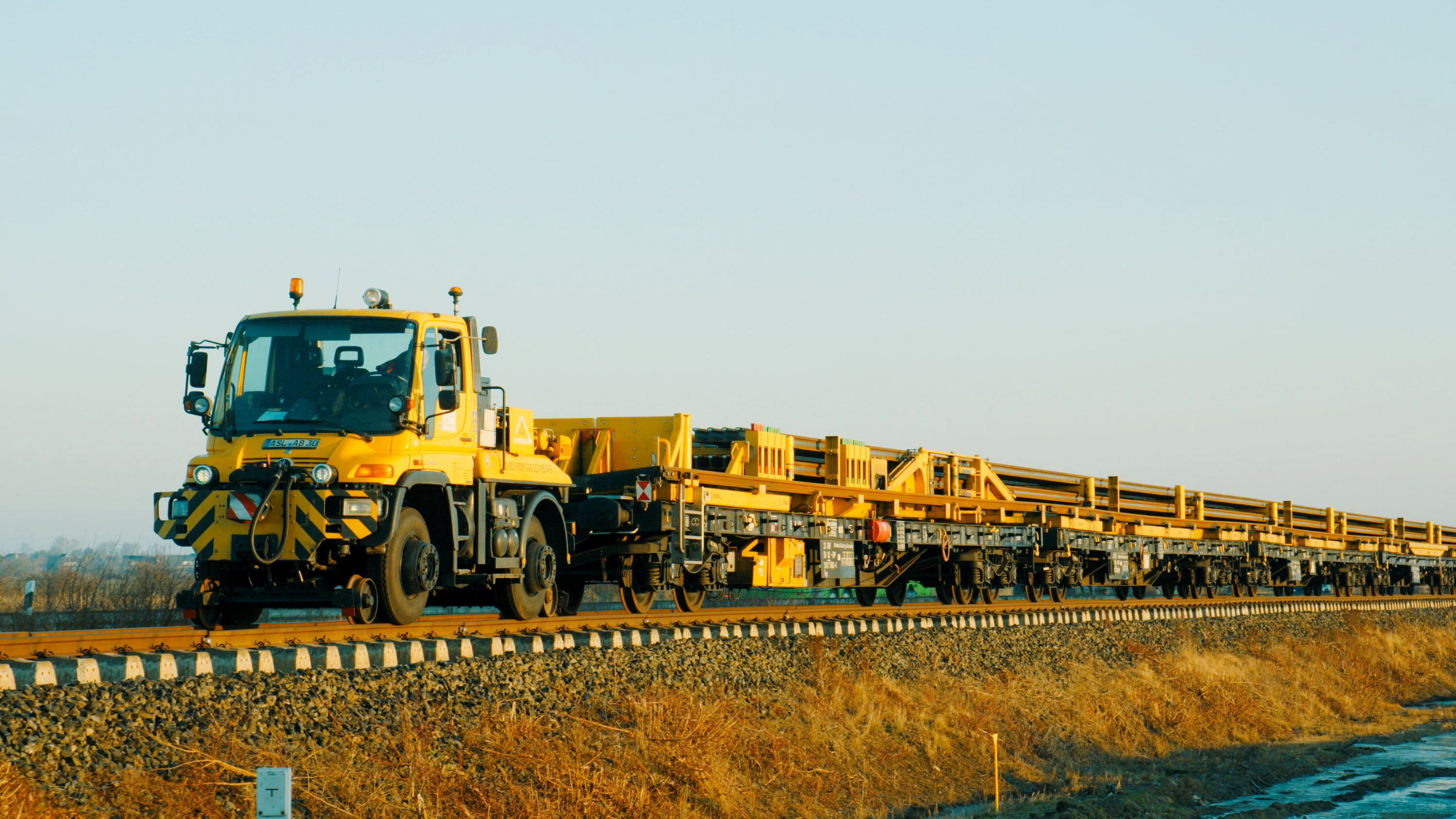 Gelber Bauzug (Unimog) auf Gleisen