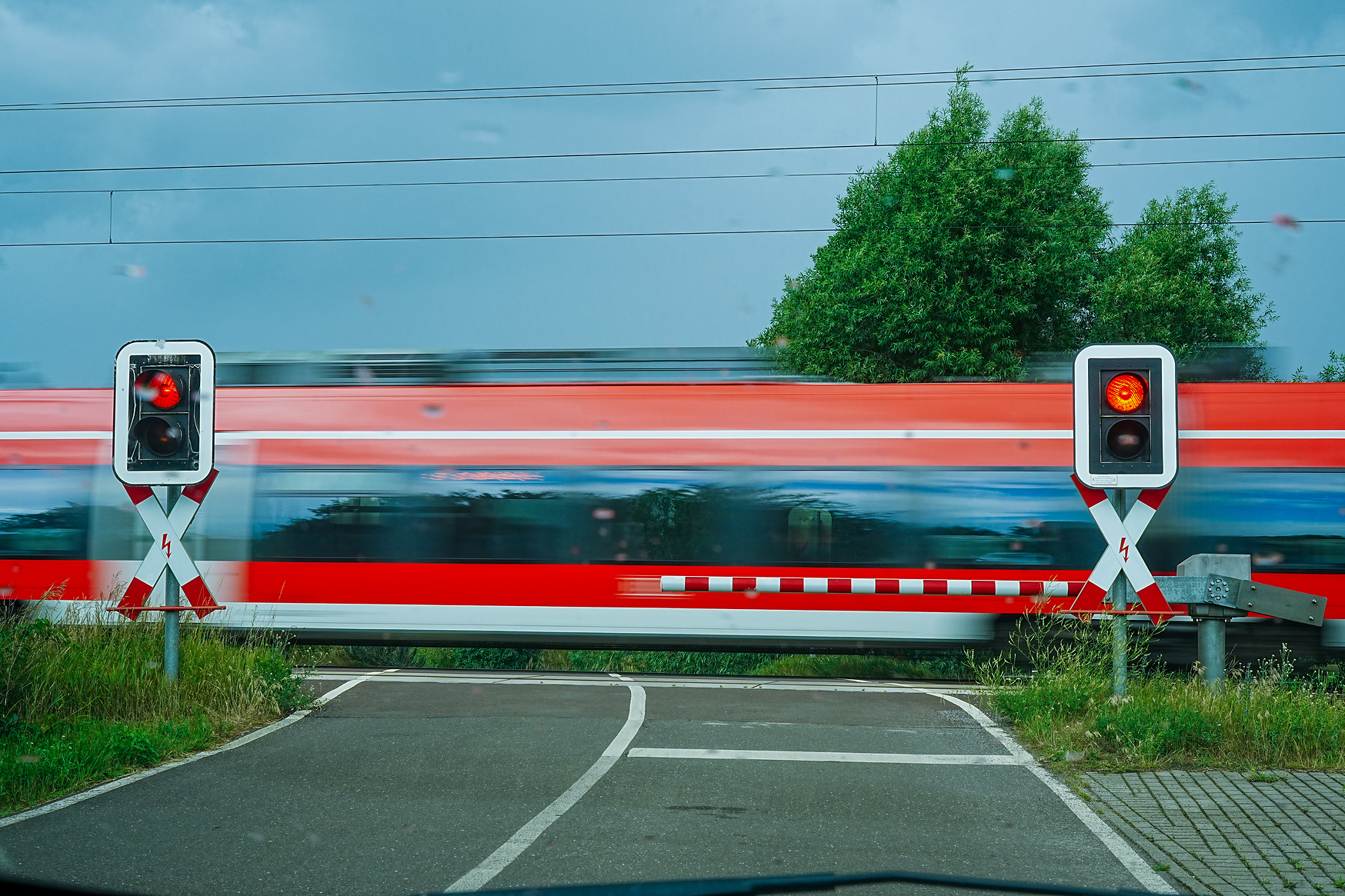 DB Regio Talent 2 (Baureihe ET 442) als RE passiert einen technisch gesicherten Bahnübergang (Halbschranke) - in Bewegungsunschärfe bei Regen (bei Brück Mark)