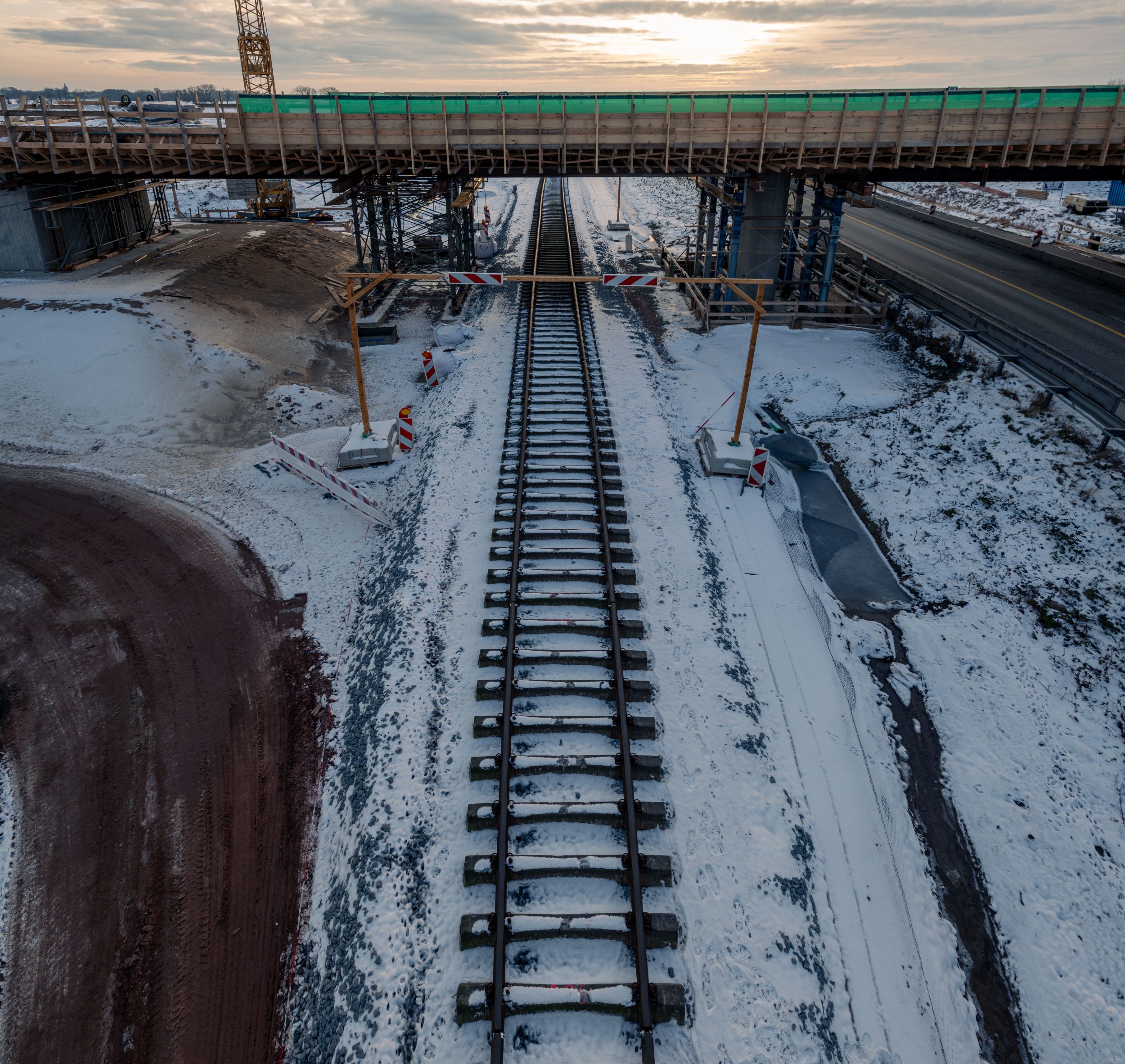 Blick auf Gleise im Schnee vor einer Brücke über die Bahntrasse